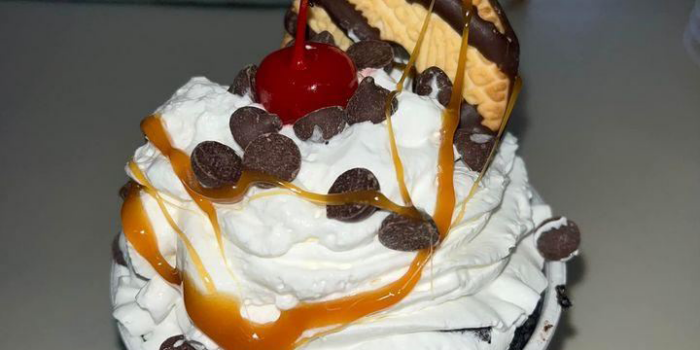r6cf-Kool-Kone-dessert-2023-02-5 Ice cream sundae with whipped cream, caramel drizzle, cookie, mini kisses, and a cherry on top